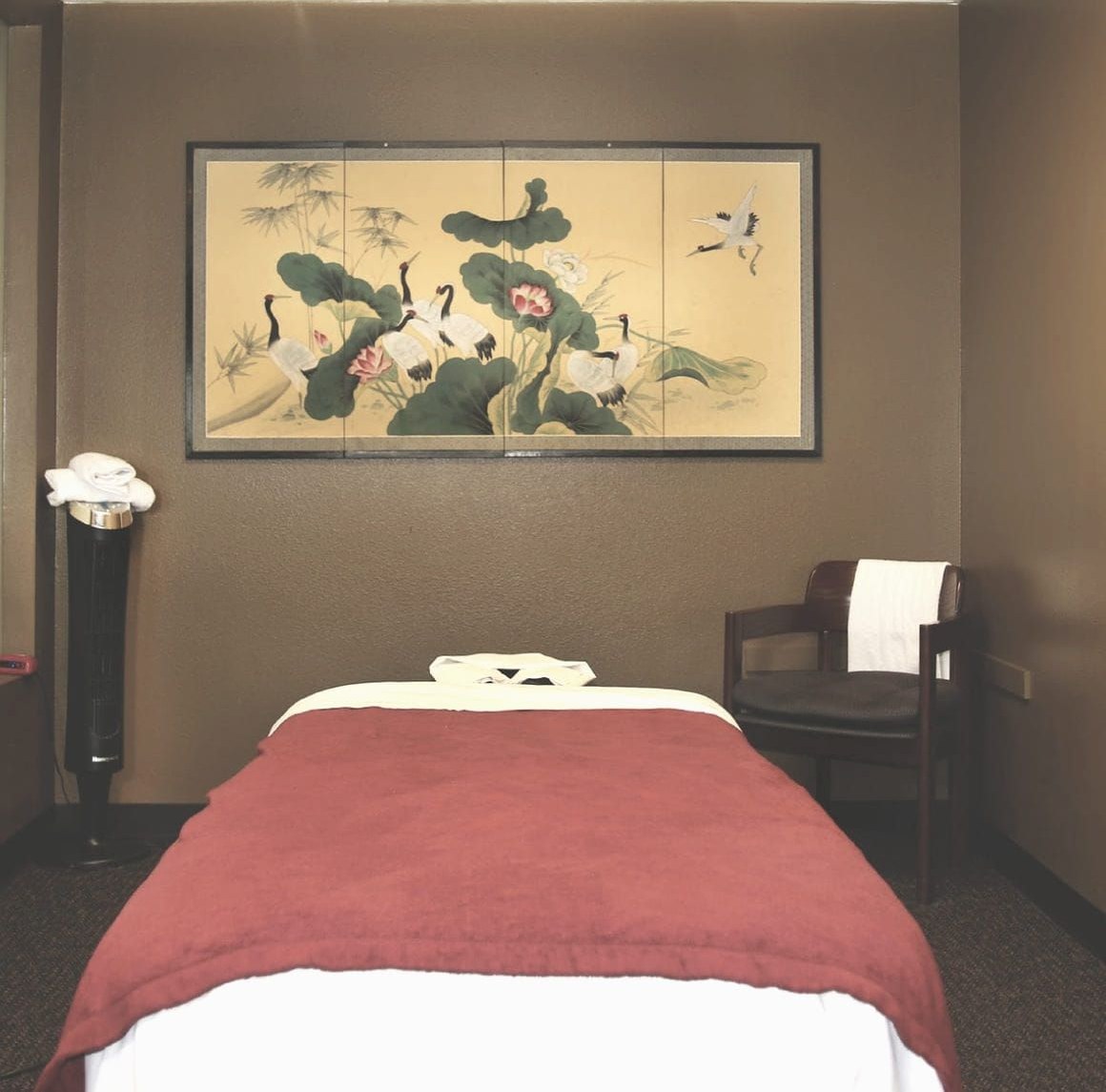 Massage room at Green Lake Spa in Seattle, with a folding screen painted with cranes above the table